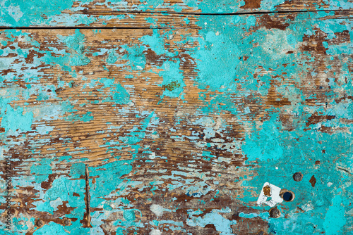 Background image of wooden surface with peeling paint. Old colorful wooden stool close-up. Picturesque texture of table with cracked of surface.