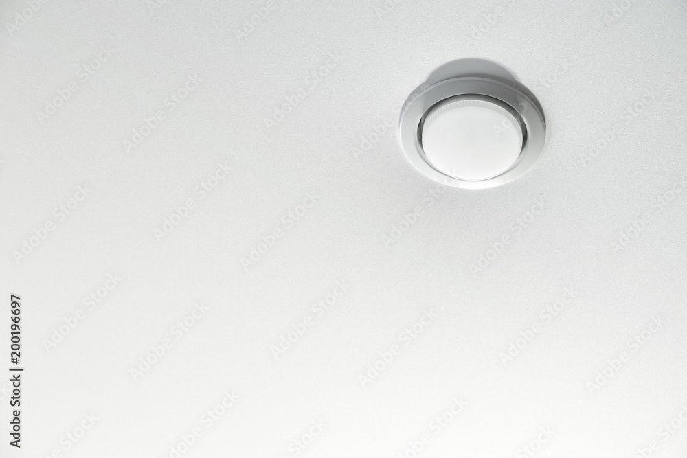 Built-in LED ceiling light in white stretch ceiling close-up. Built-in LED ceiling light in white stretch ceiling close-up.