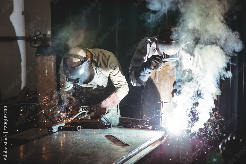 Welders working in workshop Welders working in workshop