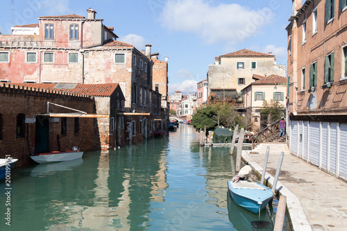 Empty Venetian street water canal with boats and old buildings 