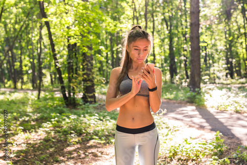 Woman using activity tracker or heart rate monitor. Outdoor fitness concept.