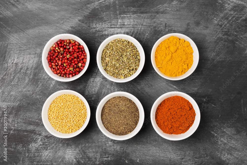 Various spices in bowls on black background. Top view. Food background
