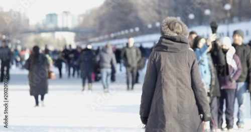 Older woman walking on rideau canal in Ottawa during winterlude photo