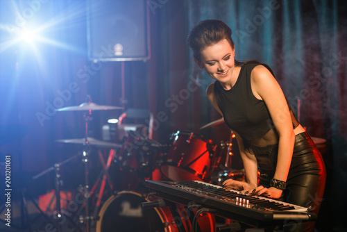 Canvas Print Young female playing keyboards on empty stage