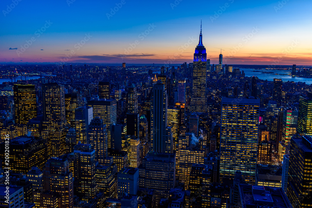 Naklejka premium New York City skyline at night - skyscrapers of midtown Manhattan with Empire State Building at Amazing Sunset - USA