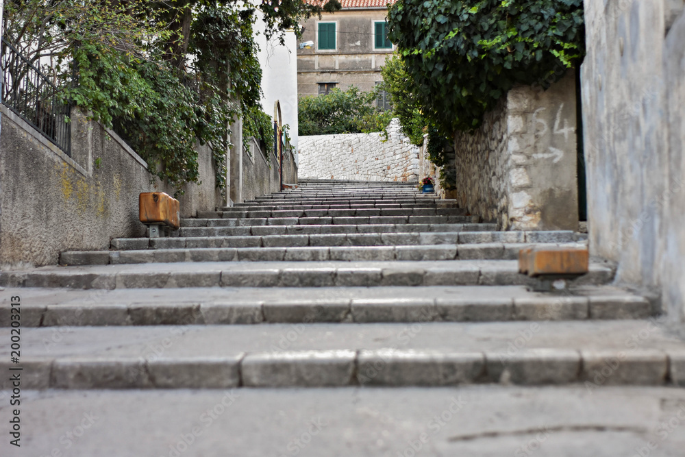 Narrow alleys with stone stairs between old brick houses In Split, Croatia