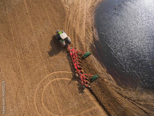 AERIAL : Tractor plowing a field - Tractor preparing the land for sowing in the spring