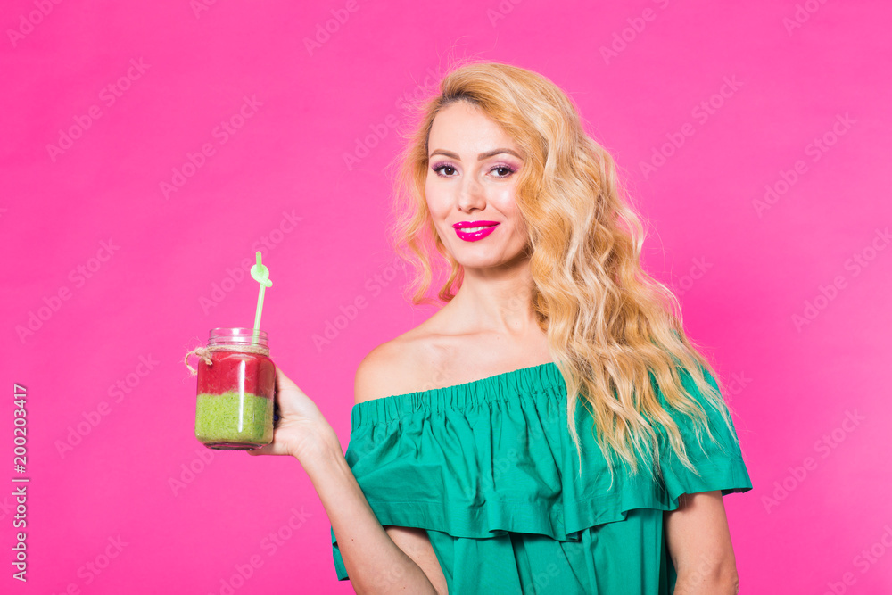 Portrait of smiling young woman drinking smoothie juice on pink background Portrait of smiling young woman drinking smoothie juice on pink background