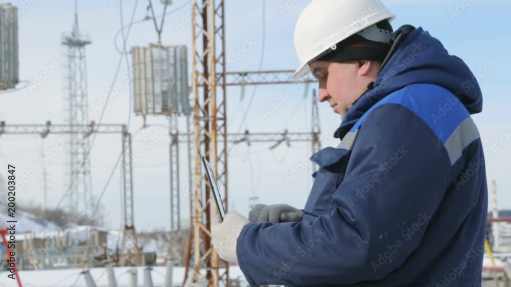 Engineer with portable computer at electric power station Engineer with portable computer at electric power station