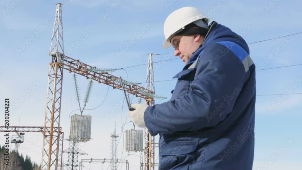 Engineer with portable computer at electric power station Engineer with portable computer at electric power station