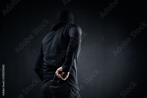 Thief hiding gun behind his back