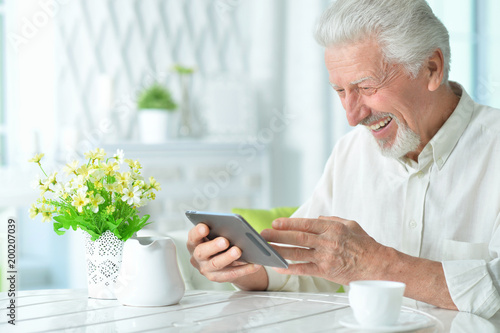 Portrait of happy senior man using tablet 