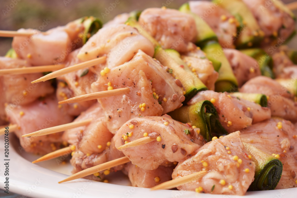 Raw Marinated Chicken Meat Skewers. Barbeque Summer Picnic Food. Grilled Meat over Wooden Background with Spices Raw Marinated Chicken Meat Skewers. Barbeque Summer Picnic Food. Grilled Meat over Wooden Background with Spices
