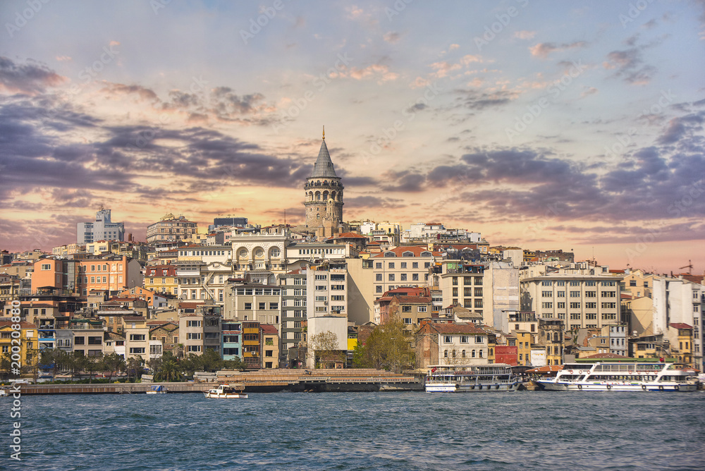 Scenery of Galata district with the famous Galata Tower over the Golden Horn, Istanbul, Turkey at sunset. Galata Tower is one of main travel attractions in the city. 