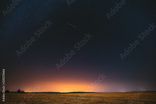 Natural Night Starry Sky Above Field Meadow. Glowing Stars, Meteorite