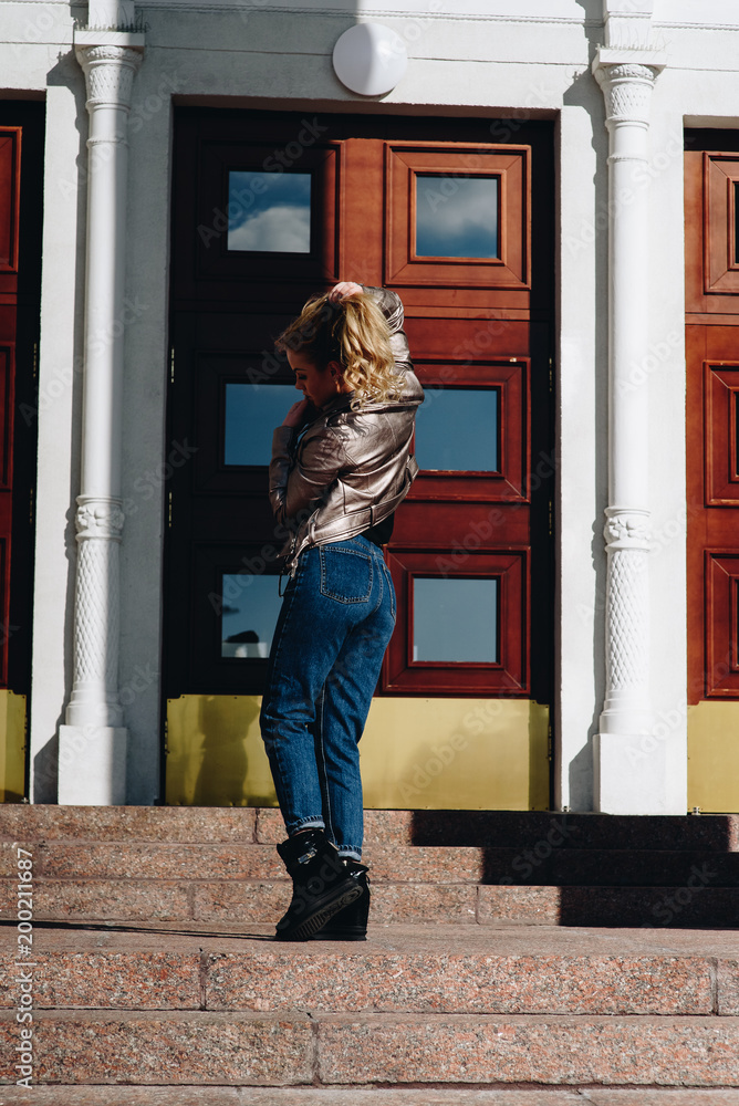 Time to relax. Cheerful young beautiful woman sitting on the parapet, hand behind head and looking with smile while, dreaming of rest day Time to relax. Cheerful young beautiful woman sitting on the parapet, hand behind head and looking with smile while, dreaming of rest day