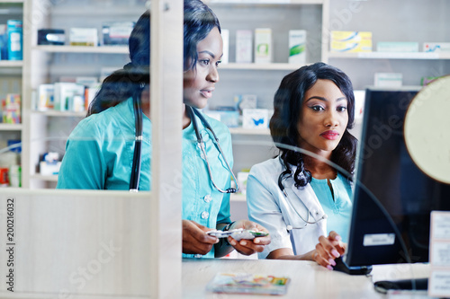 Two african american pharmacist working in drugstore at hospital pharmacy. African healthcare. photo