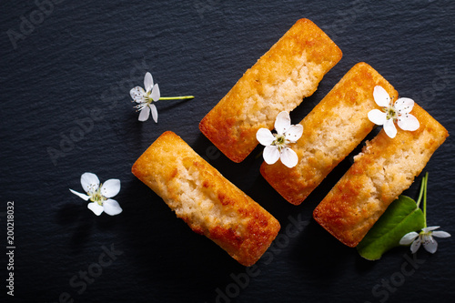 Food concept mini French almond cake financier on black slate stone with copy space