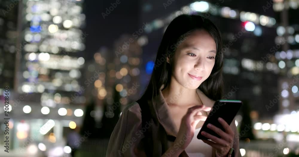 Business woman use of smart phone in city at night Business woman use of smart phone in city at night