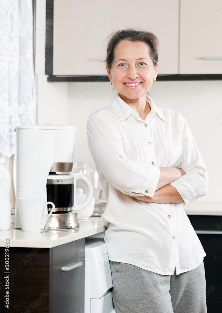 woman in kitchen near coffee machine. woman in kitchen near coffee machine.