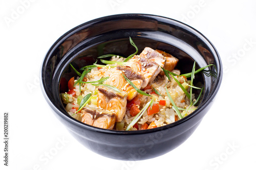 Japanese food. Rice with vegetables and fried salmon in a black bowl. Japanese food dish isolated on white background.