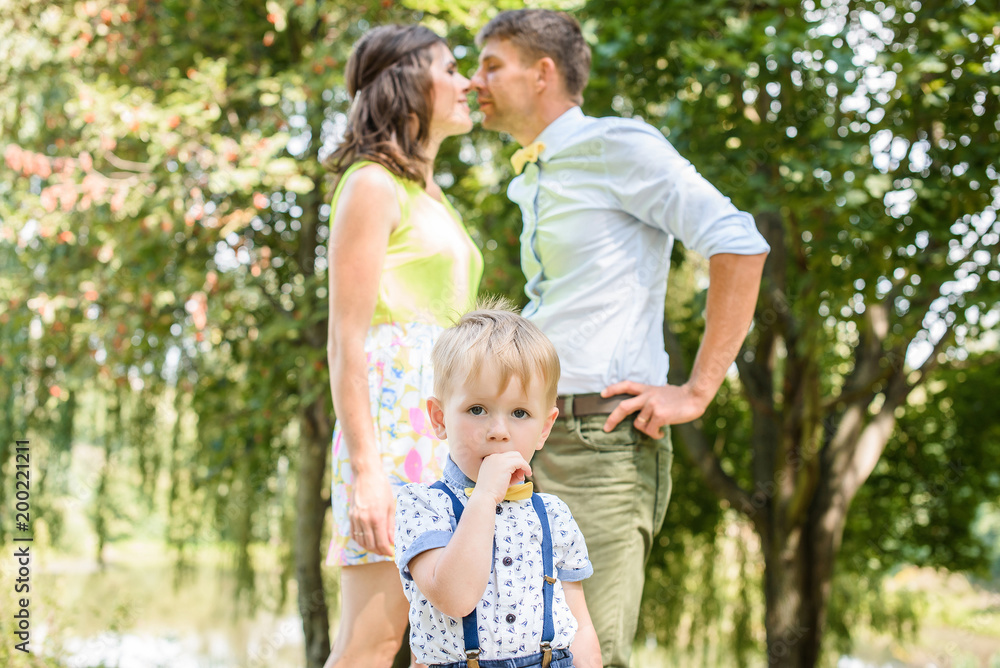 Young happy caucasian couple with little child boy. Parents and son walking and having fun together. Mother and father playing with toddler outdoors. Family, parenthood, childhood, happiness concept. Young happy caucasian couple with little child boy. Parents and son walking and having fun together. Mother and father playing with toddler outdoors. Family, parenthood, childhood, happiness concept.