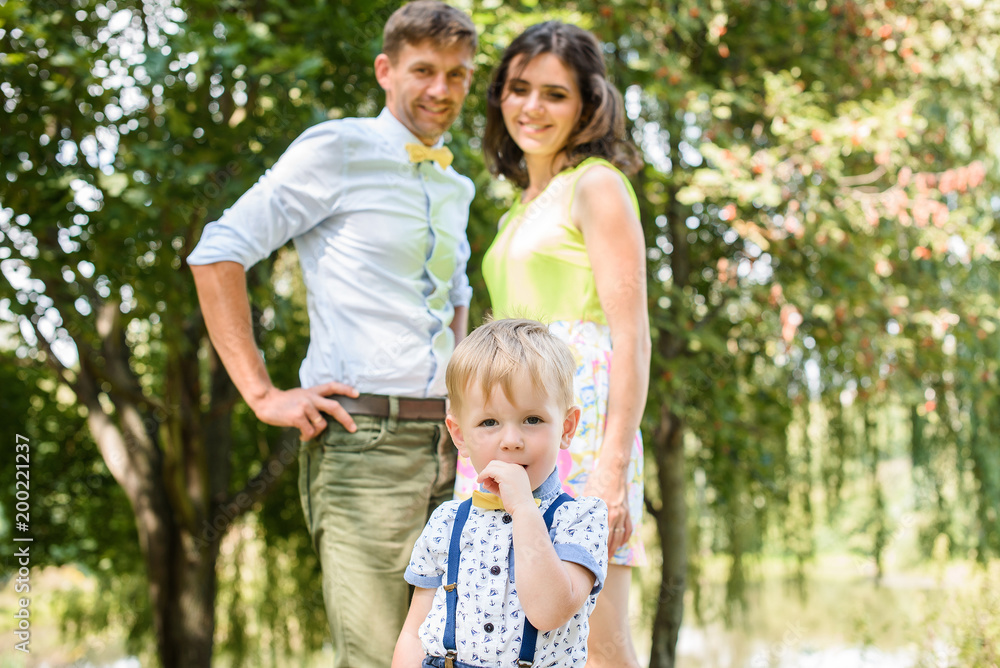 Young happy caucasian couple with little child boy. Parents and son walking and having fun together. Mother and father playing with toddler outdoors. Family, parenthood, childhood, happiness concept. Young happy caucasian couple with little child boy. Parents and son walking and having fun together. Mother and father playing with toddler outdoors. Family, parenthood, childhood, happiness concept.