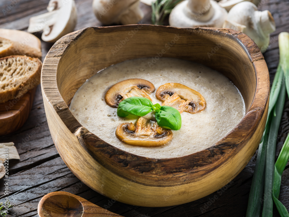 Cream soup with mushrooms on wooden table. Top view.