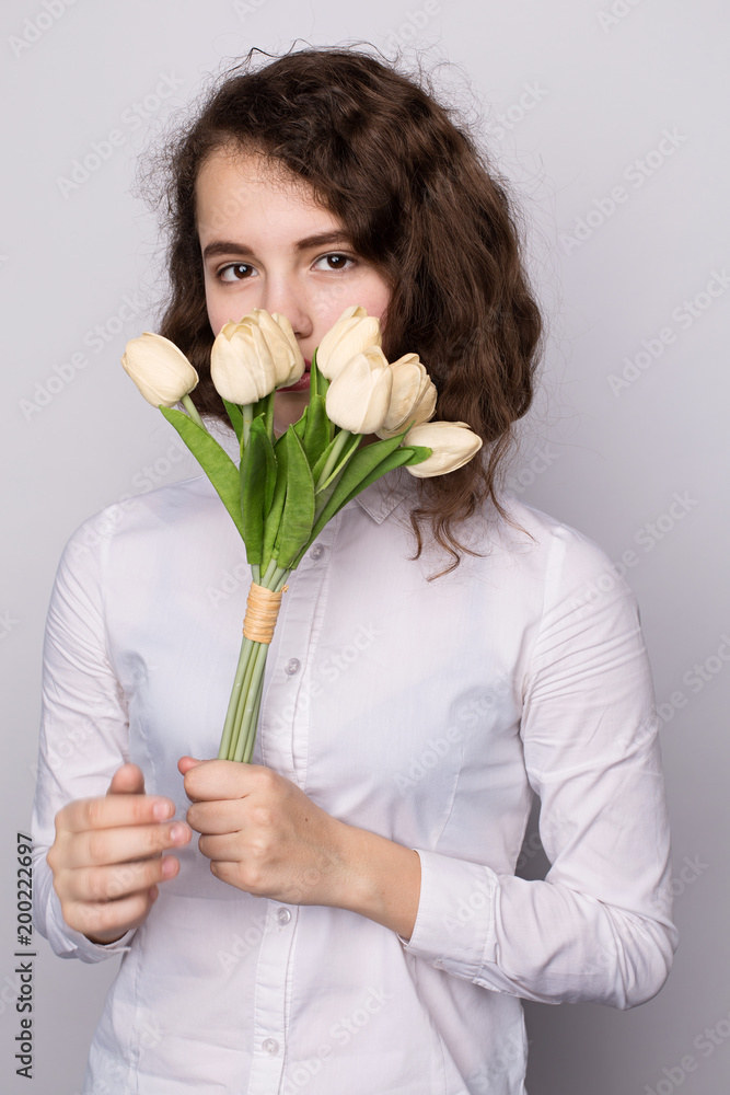 girl in a white blouse holding a bouquet of yellow and white tulips girl in a white blouse holding a bouquet of yellow and white tulips