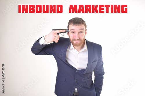 The businessman holds a gun in his hand and shows the inscription:INBOUND MARKETING