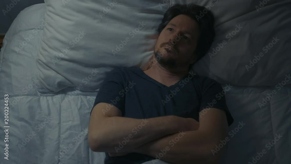 Above view of man in the bedroom leaving the bed at night.
Above view of man in the bedroom leaving the bed at night.