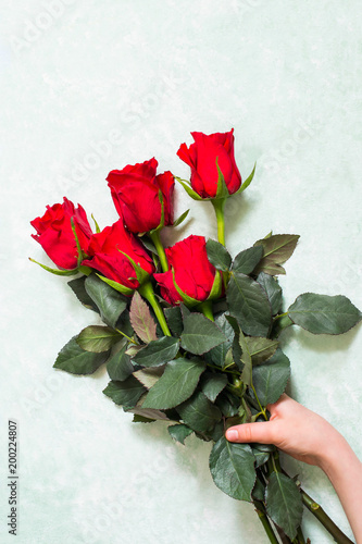 Bouquet of red roses in female hand