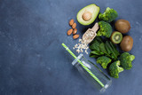 Ingredients for Healthy Green Smoothie. Broccoli, avocado, spinach, kiwi, oats and almond on blue concrete stone table background. Vegetarian Food Concept. Top view, copy space