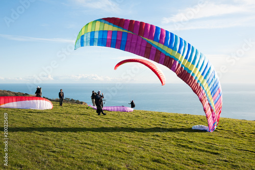 Ringstead Bay, Dorset / England. 02/15/2018. Paragliding pilots riding the wind off the cliffs of the Dorset Coast in training for the British Open Competitions in July. 