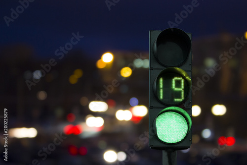 traffic light green signal on the night on the back lights of cars. Night road.