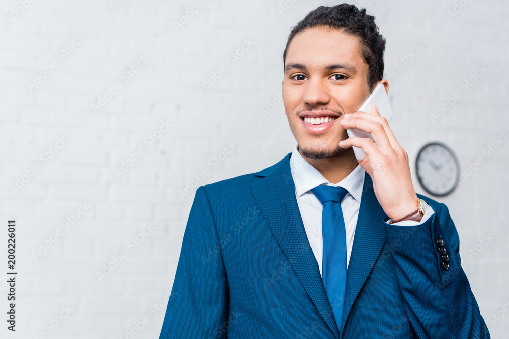 Young smiling businessman talking on the phone Young smiling businessman talking on the phone