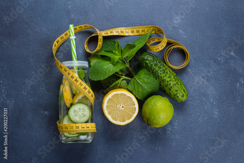 Cold detox water with lemon, cucumber and mint in glass bottle. Natural, organic healthy juice for weight loss diet or fasting day. Top view with copy space