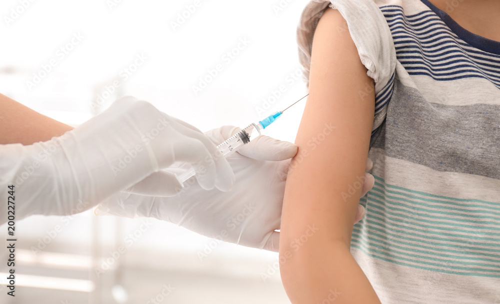 Doctor vaccinating little child in clinic, closeup Doctor vaccinating little child in clinic, closeup