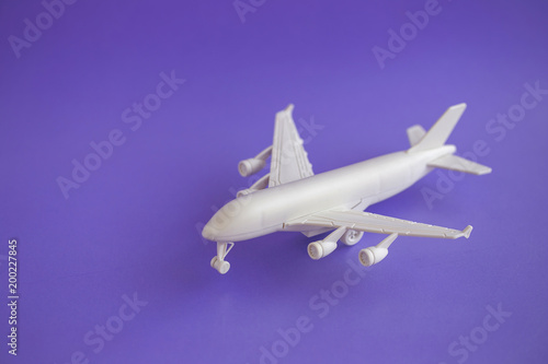 Plastic toy airplane on a violet Background and copy space