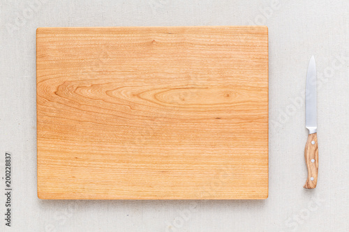 Cherry wood cutting board and knife on linen, handmade wood cutting board
