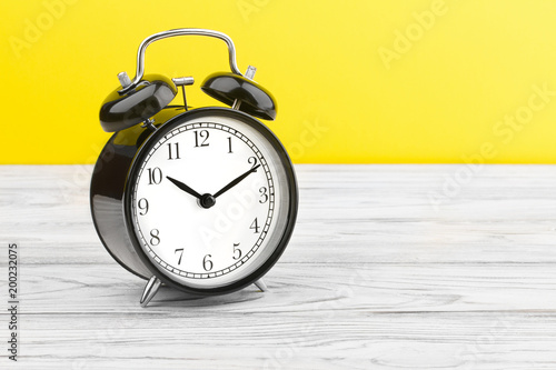 alarm clock wooden plank colored background