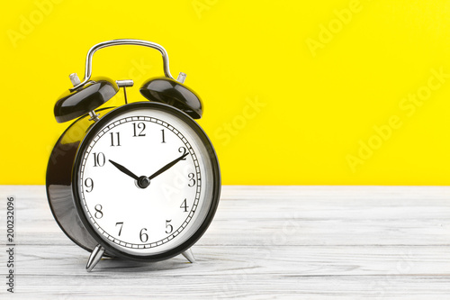 alarm clock wooden plank colored background