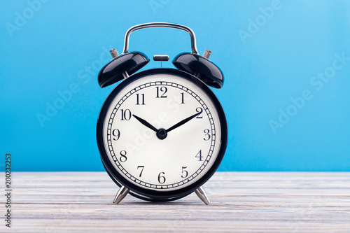 alarm clock wooden plank colored background