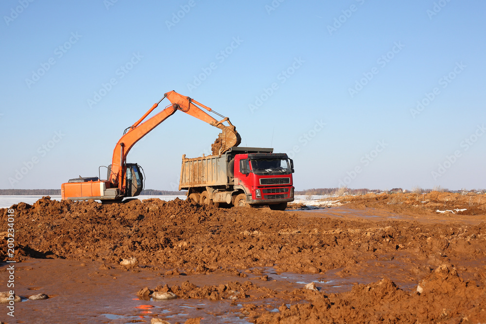 Construction - Excavator behind dump truck work Construction - Excavator behind dump truck work