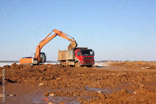 Construction - Excavator behind dump truck work