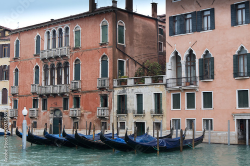 Gondolas on a pier in front of the old Venice residential buildings