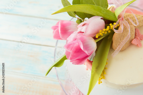 Bouquet of pink tulips on a white biscuit cake