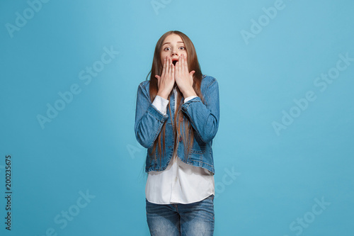 Beautiful teen girl looking suprised isolated on blue