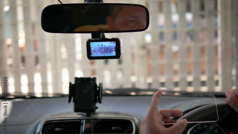 Hands of man using clear tablet in a car for transport futuristic and technology concept Hands of man using clear tablet in a car for transport futuristic and technology concept