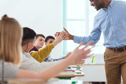 Cropped image of african american taking high five to multicultural high school teenage students